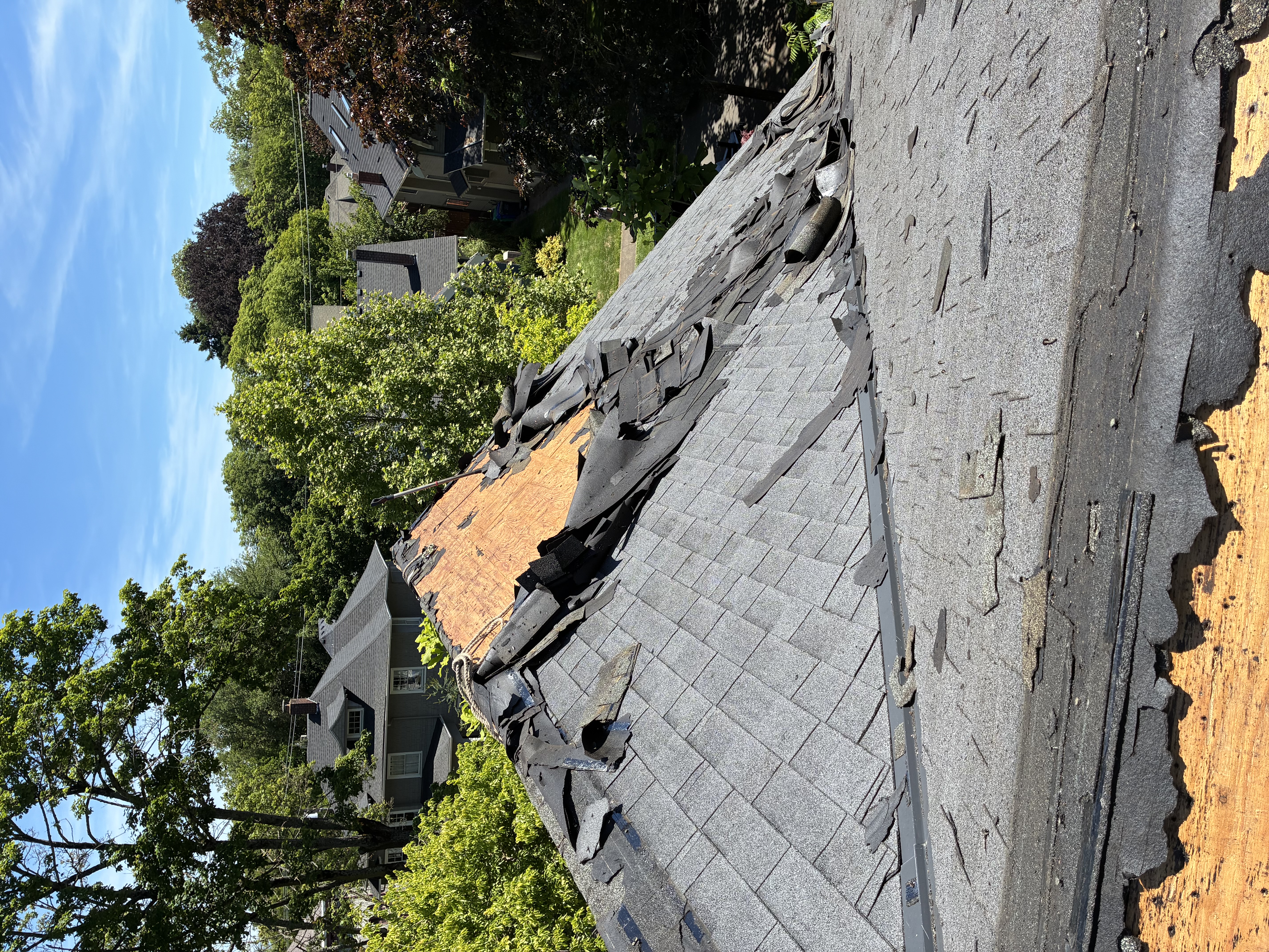 Roof tear-off showing exposed decking and underlayment on a residential home in SW Washington