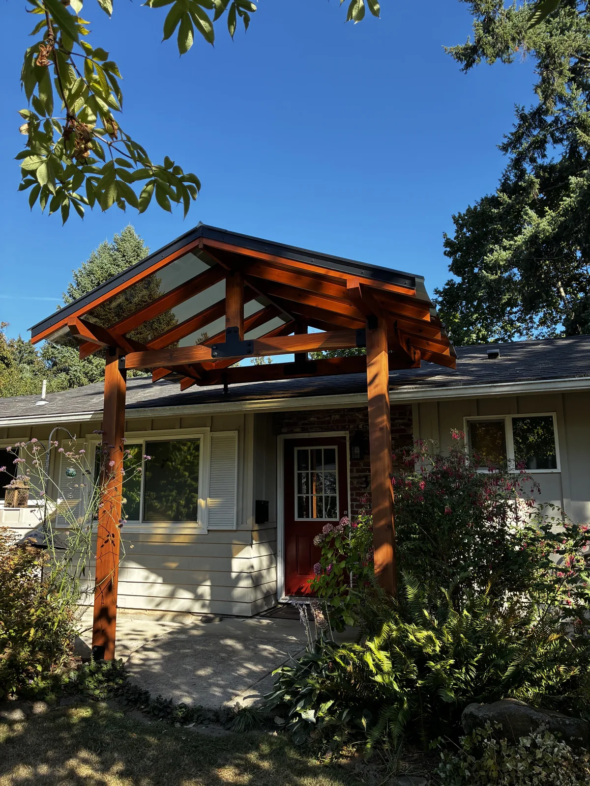 Close-up of exposed timber joinery and glass roof panels on a completed gabled entryway, Clark County WA